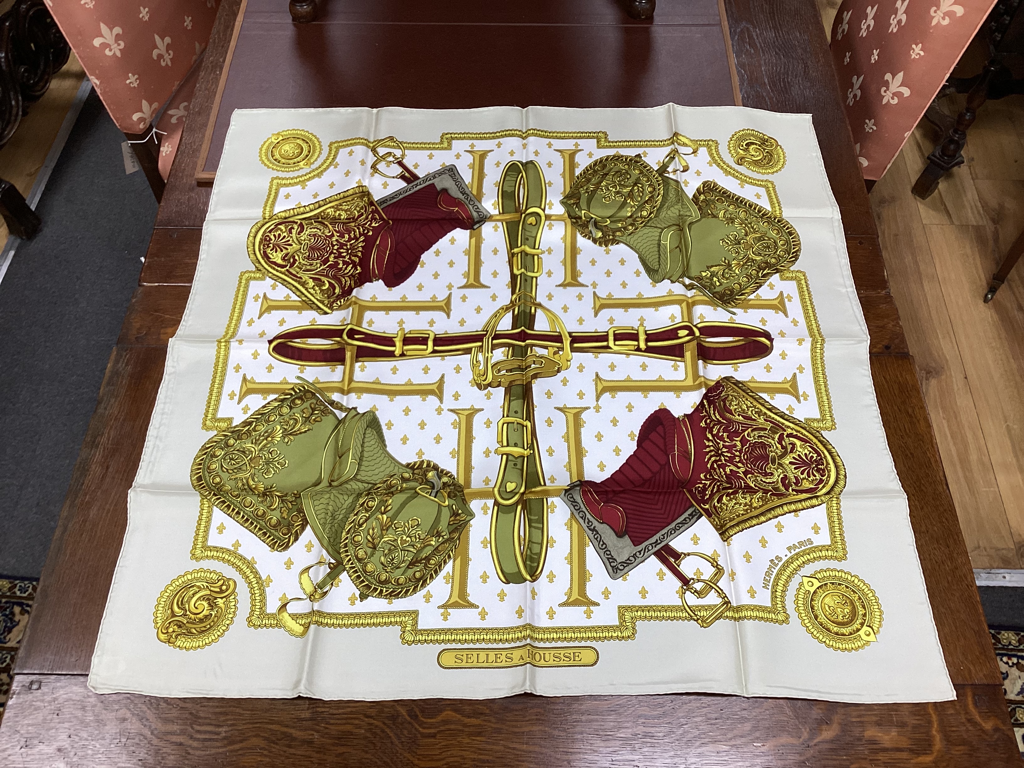 Four vintage Hermes silk scarves including one retailed by Harrods comprising, Selles A Housse, Roues de Canon, Passementerie and a rectangular Brides de Gala example